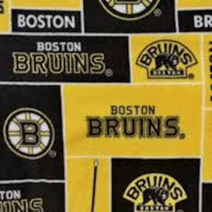 Pode incluir: Tecido preto e amarelo com um padrão repetido do logotipo dos Boston Bruins, incluindo o mascote do time, um urso, e as palavras "Boston Bruins".