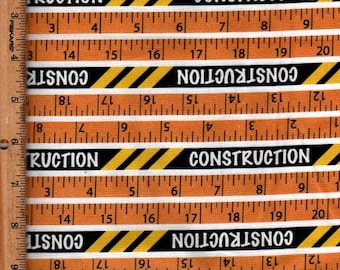 Peut inclure: Tissu orange et blanc avec des marquages de règle et le mot "CONSTRUCTION" en blanc sur un fond à rayures noires et jaunes. Le tissu a un thème de construction.