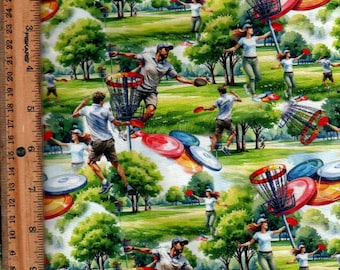 May include: A fabric print featuring a repeating pattern of people playing disc golf on a green course with trees. The design includes metal disc golf baskets, flying discs in red and blue, and a wooden ruler measuring 28 cm on the left side.