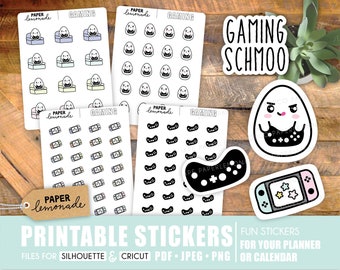 May include: Printable stickers featuring a gaming theme. The stickers include a variety of designs, such as a cartoon egg with a gaming controller, a video game console, and a controller. The text "GAMING SCHMOO" is also included on one of the stickers.