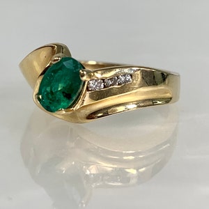 Peut inclure: Une bague en or avec une grande &eacute;meraude ovale et une rang&eacute;e de petits diamants sertis dans la bande.