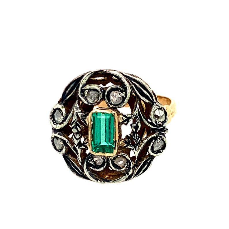 May include: A gold ring with a green emerald gemstone surrounded by a filigree design with small diamonds.