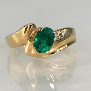 Peut inclure: Une bague en or avec une &eacute;meraude verte et de petits diamants sertis dans la bande.