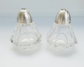 Pyramidenförmiger Salz- und Pfefferstreuer aus klarem Glas mit verchromten Kunststoffkappen. C-1