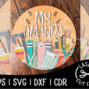 Könnte beinhalten: Ein rundes Holzschild mit dem Text "MS. AMANDA" in weißen Buchstaben. Das Schild ist mit verschiedenen Schulutensilien verziert, darunter Bleistifte, Lineale, ein Taschenrechner und Bücher. Das Schild ist perfekt für ein Lehrerzimmer oder ein Kinderzimmer.