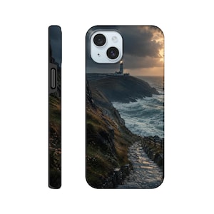 May include: A smartphone case featuring a photographic print of a coastal landscape at sunset. The image displays a lighthouse on a cliff overlooking a turbulent ocean with white-capped waves, a stone path leading toward the water, and dark clouds.