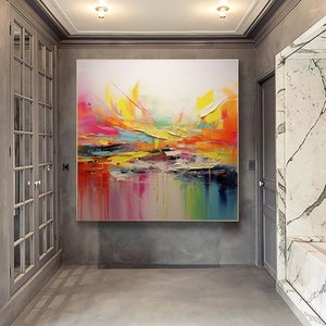 May include: Abstract painting with vibrant colors, including yellow, pink, blue, and green. The painting has a textured, layered look, with thick brushstrokes and drips of paint.