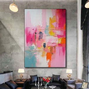 K&ouml;nnte beinhalten: Abstrakte Malerei mit einer lebendigen Mischung aus Rosa, Orange, Gelb und Blau. Das Kunstwerk verwendet dicke Pinselstriche, die eine strukturierte Oberfl&auml;che erzeugen. Das Gem&auml;lde wird an einer grauen Wand gezeigt.