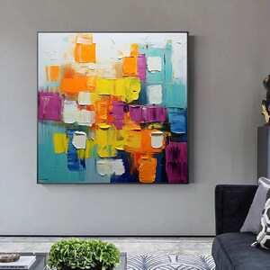 May include: Abstract painting with a colorful, geometric design. The painting features a variety of colors, including yellow, orange, blue, purple, and white. The colors are applied in a thick, textured style, creating a dynamic and energetic composition.