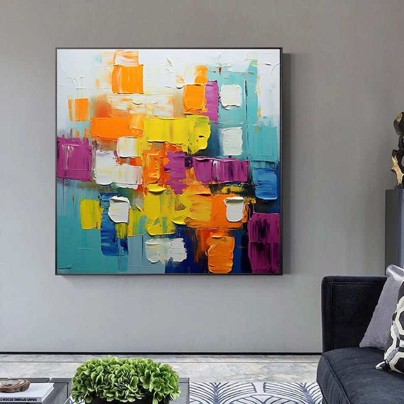 May include: Abstract painting with a colorful, geometric design. The painting features a variety of colors, including yellow, orange, blue, purple, and white. The colors are applied in a thick, textured style, creating a dynamic and energetic composition.