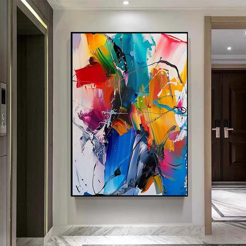 Puede incluir: Pintura abstracta con trazos audaces de color, incluyendo rojo, amarillo, azul, verde y rosa. La pintura est&aacute; enmarcada en negro y cuelga de una pared blanca.