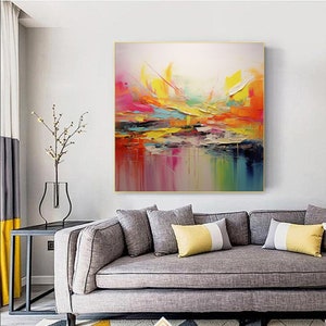 May include: Abstract painting with vibrant colors, including yellow, orange, pink, and blue. The painting has a textured, brushstroke effect and is framed in a gold frame.