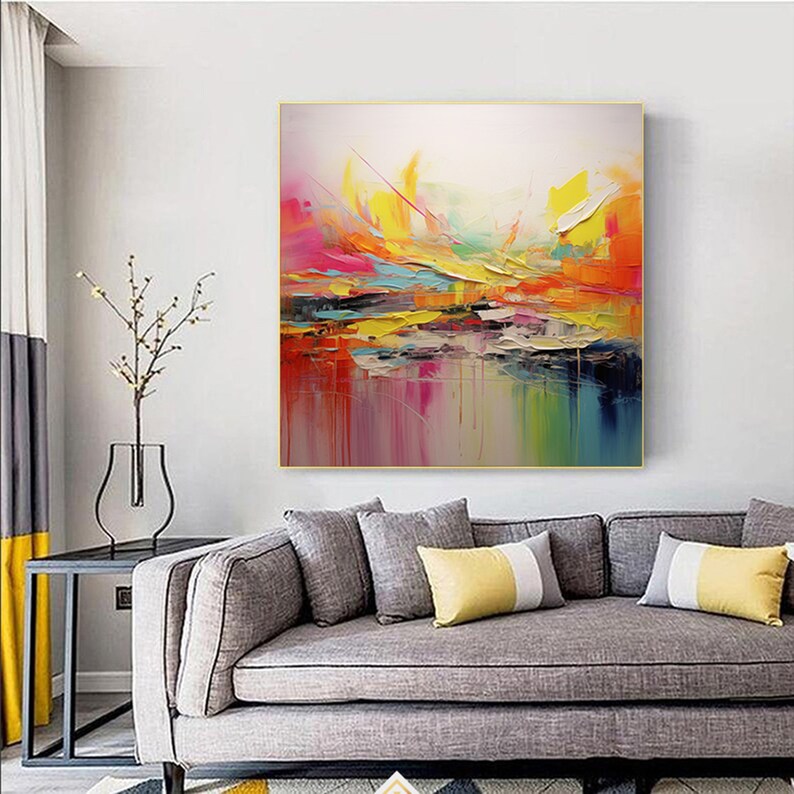 May include: Abstract painting with vibrant colors, including yellow, orange, pink, and blue. The painting has a textured, brushstroke effect and is framed in a gold frame.