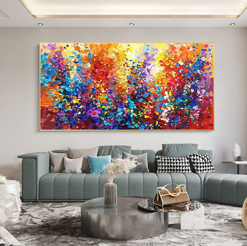 May include: Abstract painting with a colorful, textured, and vibrant design. The painting features a mix of blue, purple, yellow, orange, red, and green colors. The painting is framed in a gold frame.