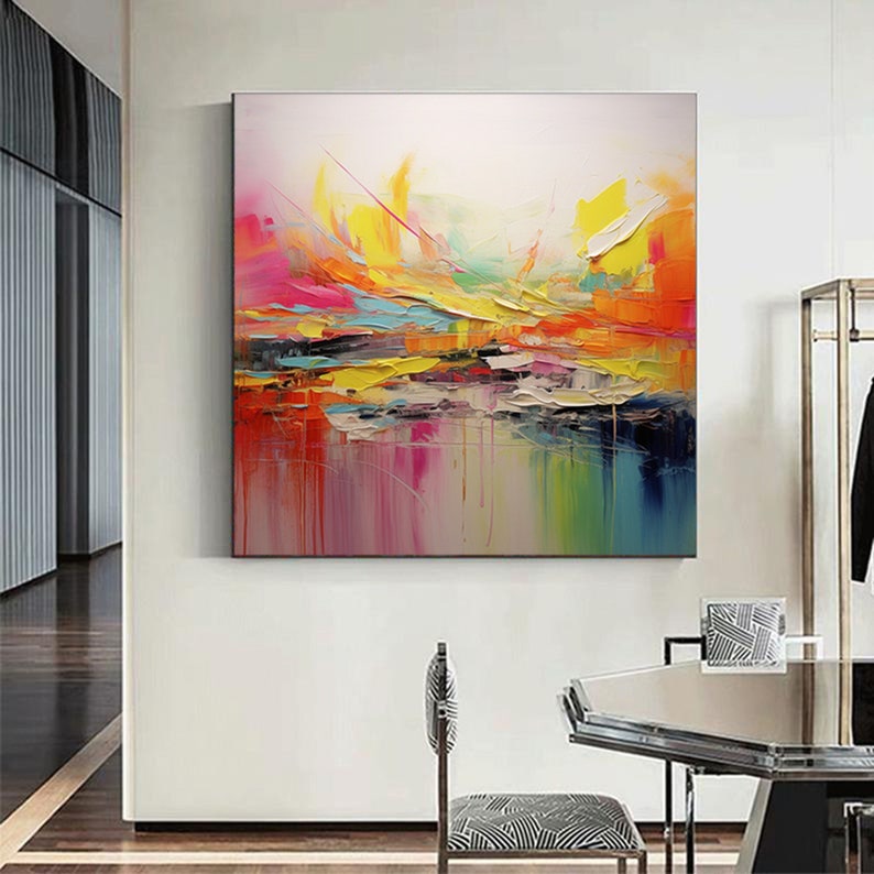 May include: Abstract painting with vibrant colors, including yellow, orange, pink, blue, and green. The painting has a textured, layered look, with thick brushstrokes and drips of paint.