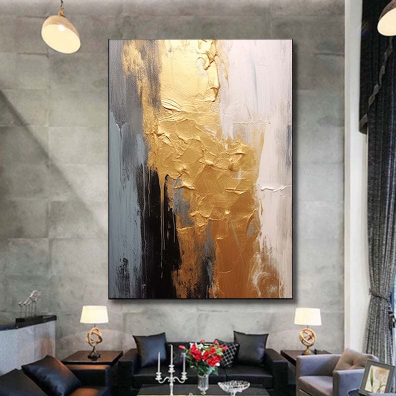 Puede incluir: Pintura abstracta con pinceladas doradas, blancas y grises sobre un lienzo. La pintura dorada es texturizada y tiene un brillo met&aacute;lico.
