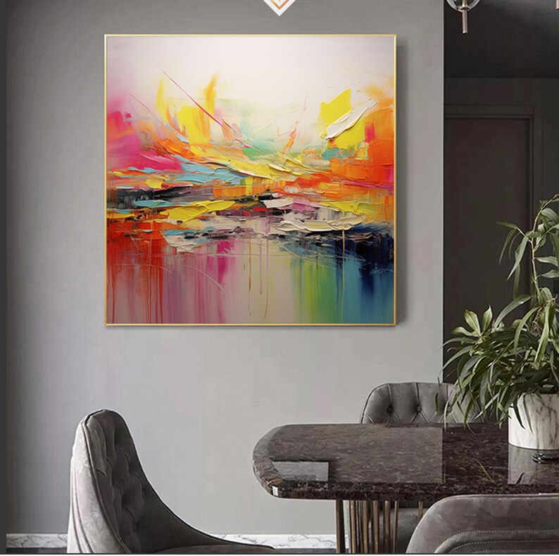 May include: Abstract painting with a colorful, layered design. The painting features shades of pink, yellow, orange, blue, and green. The colors are blended together to create a dynamic and energetic composition.