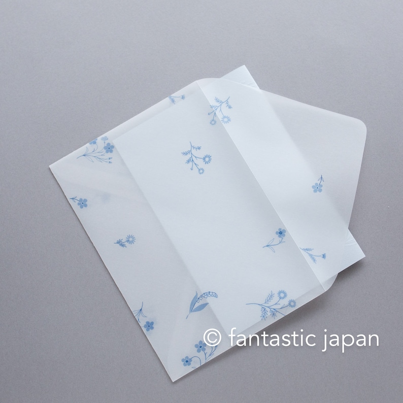 Pode incluir: Envelope de papel branco com um delicado padr&atilde;o floral azul. O envelope est&aacute; dobrado e tem uma aba. O texto "fantastic japan" est&aacute; no canto inferior direito.