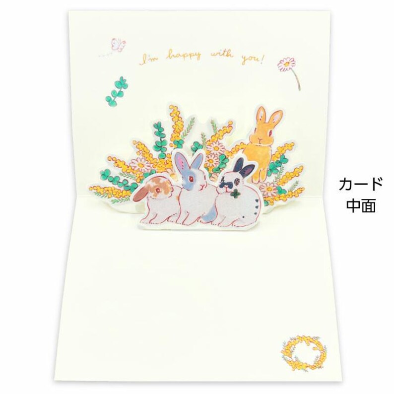 May include: A pop-up card featuring a 3D scene of four bunnies in a field of yellow flowers. The card reads "I'm happy with you!"