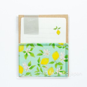 May include: A stationery set featuring a lemon theme. The set includes a notepad with a lemon illustration and a decorative cover with a lemon and floral pattern. The set is packaged in a clear plastic sleeve.