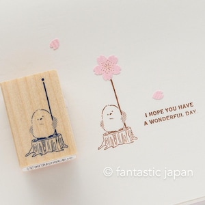 Peut inclure: Un tampon en bois avec une illustration mignonne d'un oiseau tenant une fleur de cerisier rose. Le tampon indique "J'espère que vous avez une merveilleuse journée."