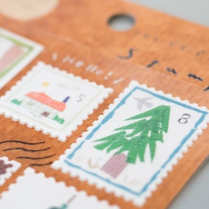 May include: A sheet of decorative stamps with a brown background. The stamps feature illustrations of a house, a tree, and a bird. The text "Hello!" and "Adventure Stamp" are printed on the sheet.