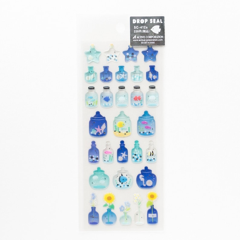 Puede incluir: Una hoja de pegatinas transparentes con una variedad de botellas de vidrio azul que contienen criaturas marinas, estrellas de mar y flores. Las pegatinas est&aacute;n etiquetadas como "DROP SEAL" y "SC-4128".