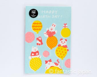 May include: A light blue birthday card with the text "HAPPY BIRTH DAY!" and illustrations of animals on balloons. The card features a rabbit, panda, cat, and bear, along with yellow and pink balloons. The card is in a clear plastic sleeve.