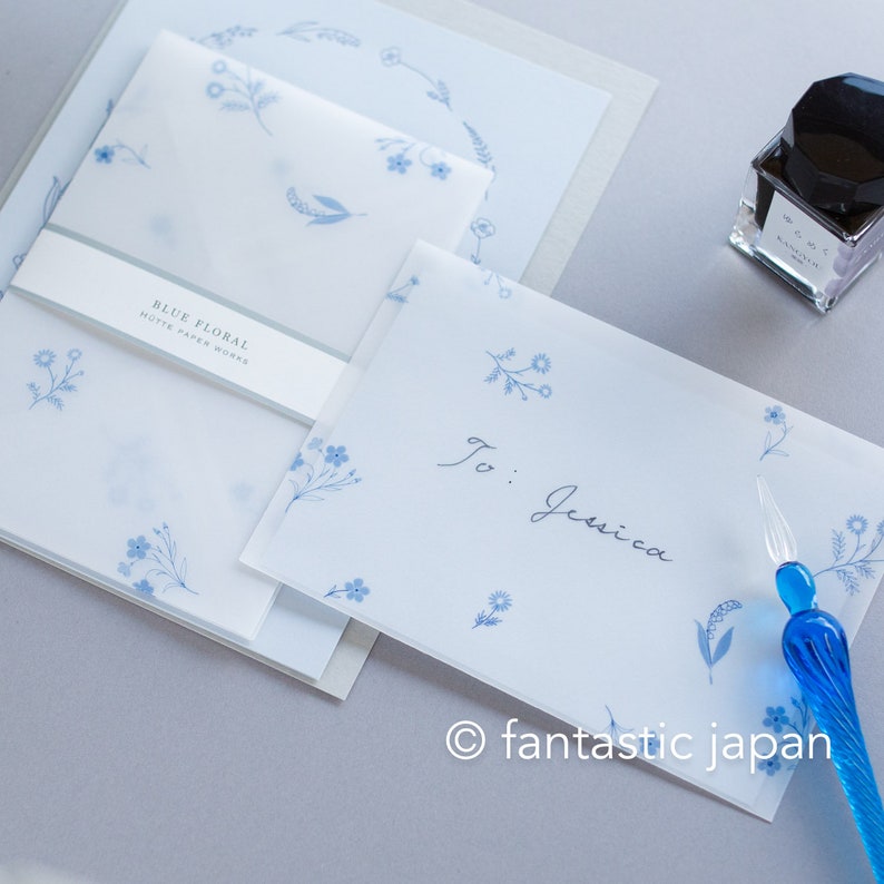Pode incluir: Conjunto de papelaria branco com desenhos florais azuis. Inclui envelopes, cart&otilde;es e uma caneta. O texto "Blue Floral" &eacute; vis&iacute;vel na embalagem. O envelope &eacute; endere&ccedil;ado a "To: Jessica".