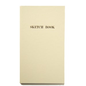 Puede incluir: Un cuaderno de bocetos rectangular con una cubierta de color crema. Las palabras "SKETCH BOOK" están impresas en una fuente marrón oscuro en la parte superior de la cubierta. La cubierta tiene una superficie texturizada.