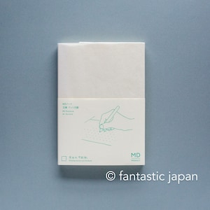 May include: A white MD notebook with a paper band featuring green text and a line drawing of a hand writing on a dotted grid. The text includes MD Notebook A6 Dot Grid and the phrase Pasing notes too forward. The MD PRODUCT logo is in the corner.
