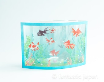 Op de afbeelding: Een pop-upkaart die een aquarium voorstelt met een blauwe rand en verschillende oranje en zwarte vissen die erin zwemmen. Het aquarium is gevuld met blauw water en heeft groene planten en bubbels.