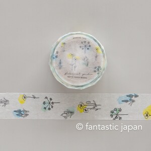 Puede incluir: Un rollo de cinta washi con un dise&ntilde;o floral. La cinta es blanca con acentos acuarela azul y amarillo. La cinta est&aacute; etiquetada como "Botanical Garden" y "Mutte Paper Works".
