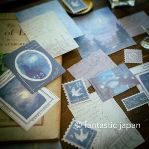 May include: A collection of stationery items with a vintage aesthetic. The image features various blue and white postcards, stamps, and papers with illustrations of night scenes, moons, and buildings. The text "fantastic japan" is visible.