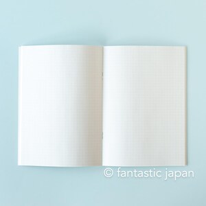 May include: Open notebook with grid paper on a light blue background. The notebook is open to a double-page spread, with the pages appearing blank. The text "fantastic japan" is at the bottom right.