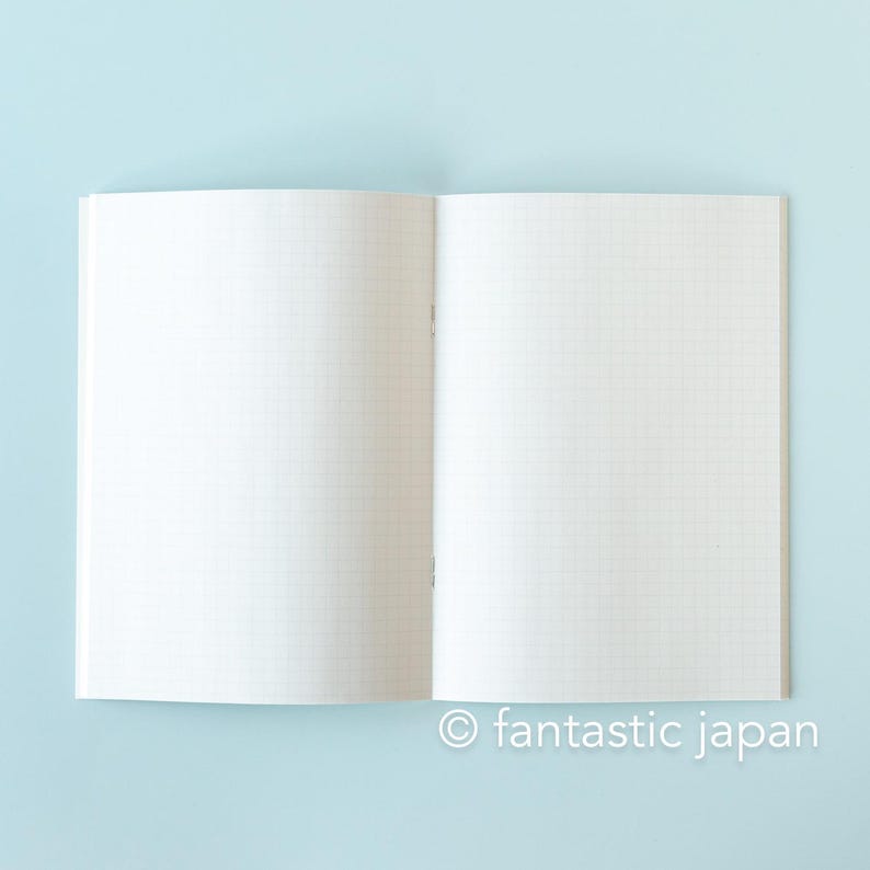 May include: Open notebook with grid paper on a light blue background. The notebook is open to a double-page spread, with the pages appearing blank. The text "fantastic japan" is at the bottom right.