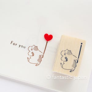 Peut inclure: Un tampon en bois avec une illustration de dessin animé d'un ours tenant un ballon rouge en forme de cœur. Le tampon est sur un fond blanc avec le texte "For you" écrit à l'encre brune.