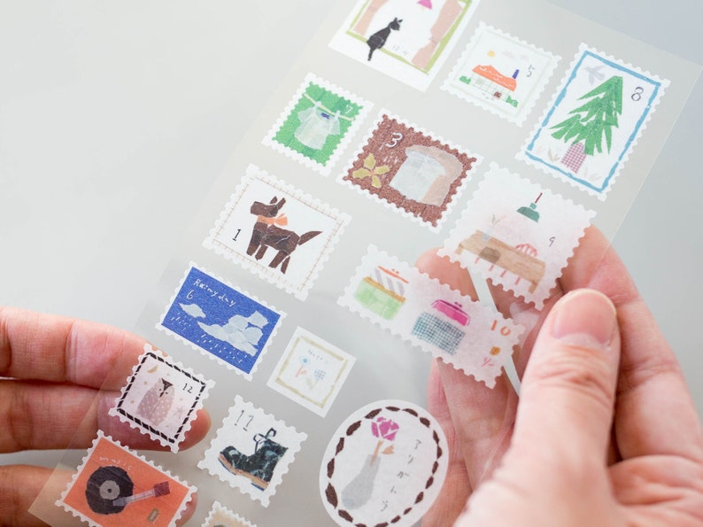 May include: A sheet of clear stickers with various illustrations, including a dog, a house, a tree, a lamp, and a boot. Each sticker is framed with a white border and has a number in the corner.