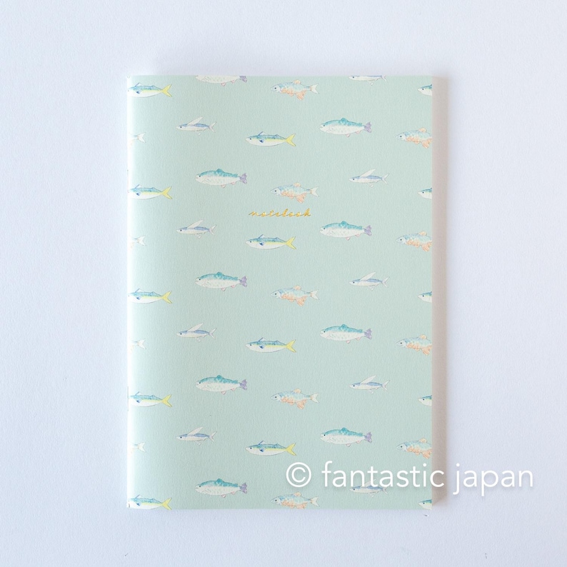 May include: A notebook with a light green cover featuring a pattern of various fish in shades of blue, orange, and gray. The word "waterlili" is written in cursive. The text "fantastic japan" is at the bottom.