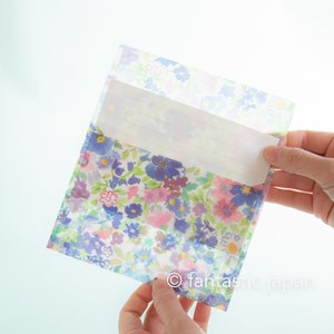May include: A floral patterned envelope with a white lined sheet of paper inside. The envelope is translucent and the floral pattern is visible through the paper.