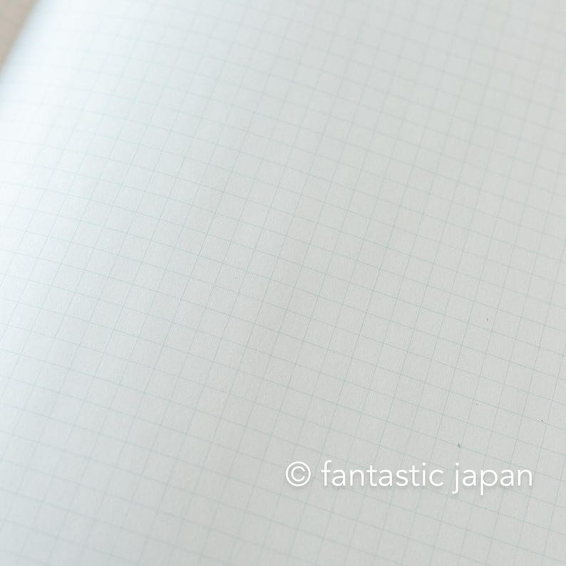 May include: Close-up of a blank, white notebook page with a subtle grid pattern. The page is clean and ready for writing or drawing. The text "fantastic japan" is in the bottom right corner.