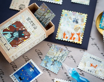 Postage flake stickers in a match box -The Snow Crossing -