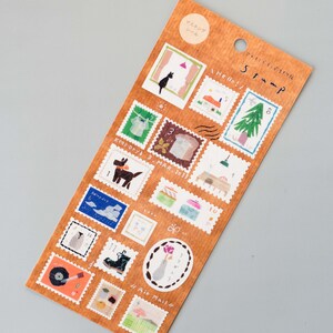 May include: A sheet of brown paper with 16 illustrated stamps featuring various designs, including a cat, a dog, a tree, a house, a record player, and a bird. The stamps are labeled with numbers 1 through 16. The sheet is titled "Stamp".