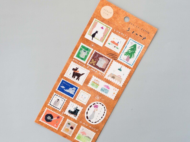 May include: A sheet of brown paper with 16 illustrated stamps featuring various designs, including a cat, a dog, a tree, a house, a record player, and a bird. The stamps are labeled with numbers 1 through 16. The sheet is titled "Stamp".