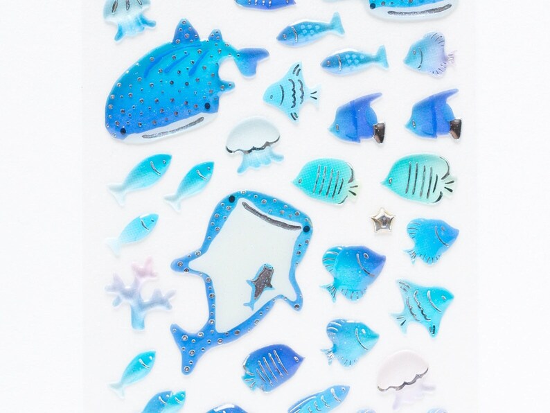 May include: A sheet of blue and white stickers featuring various sea creatures, including a whale shark, jellyfish, and fish. The stickers are ideal for adding a touch of whimsy to journals, planners, or other craft projects.