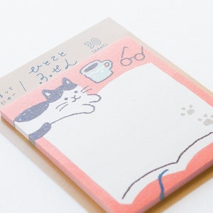 May include: A pack of 30 pink and white sticky notes featuring a black and white cat reading a book with a cup of coffee and glasses on top. The notes have the text "freeze 3.3.21" on the back.