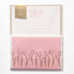 Puede incluir: Un juego de papeler&iacute;a rosa y blanca con un dise&ntilde;o de tulip&aacute;n dorado. El juego incluye 6 papeles, 3 sobres y 3 juegos de pegatinas. El texto en el paquete dice "sucr&eacute; letter set".