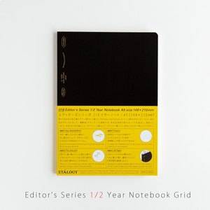 May include: Black notebook with a yellow label that says "018 Editor's Series 1/2 Year Notebook A5 size 148x210mm" and "エディターズシリーズ 1/2 イヤーノート/A5(148×210mm)". The label also includes details about the notebook's features, such as the grid paper and the number of pages.