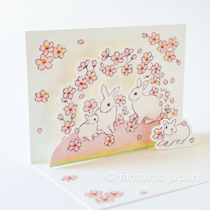 Cartão de felicitações de Schinako Moriyama -Coelhos nas flores de cerejeira-