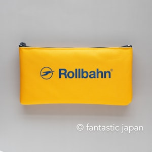 May include: Yellow zippered pouch with the logo "Rollbahn" in blue text.